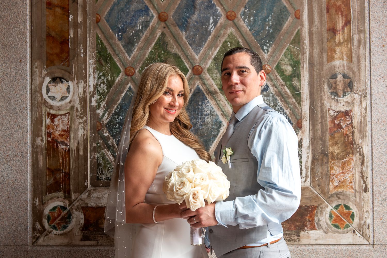 Couple shares intimate moments against backdrop of decorative wall murals.