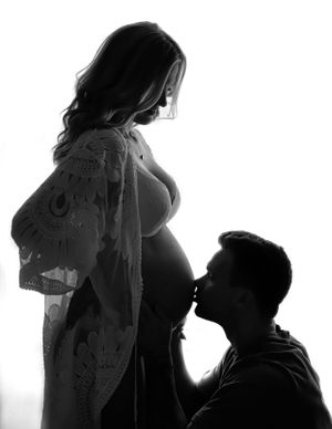 Silhouette maternity photo showing loving couple moment with pregnant belly.