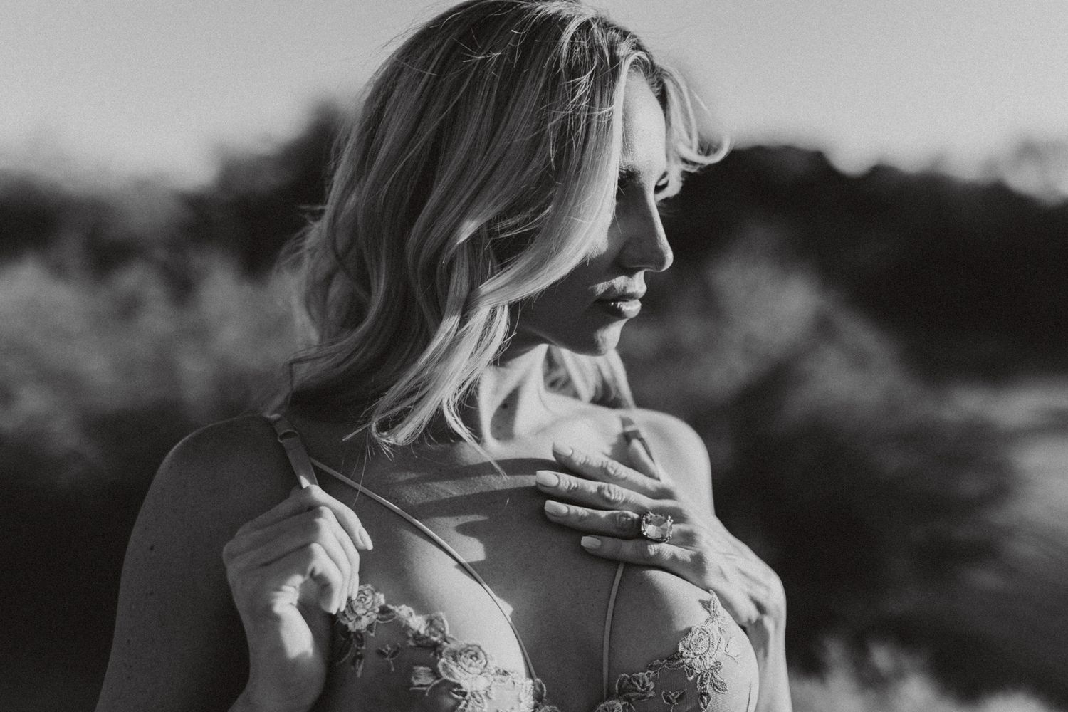 Artistic black and white portrait with dramatic lighting and delicate lace details.