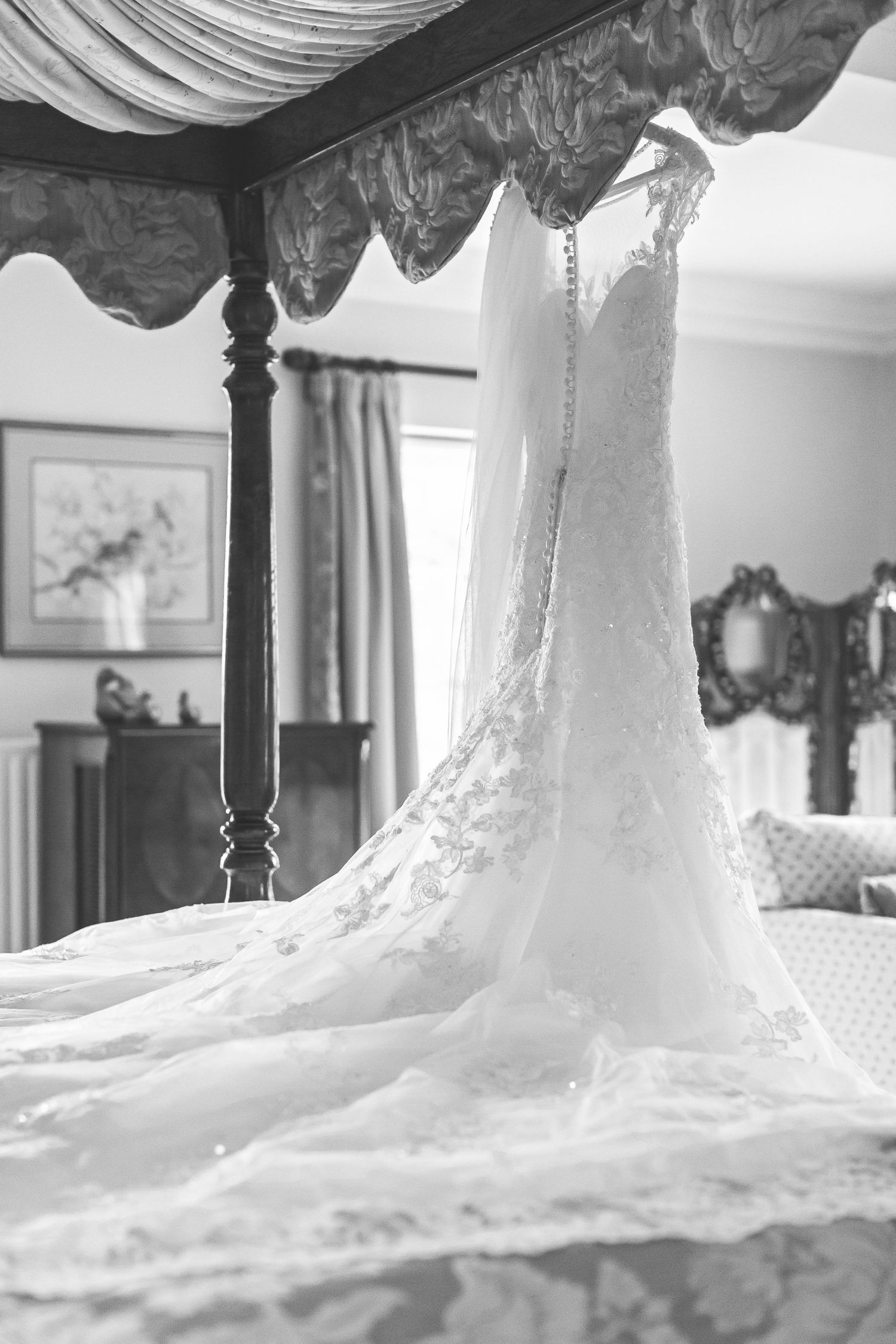 Hayley Elizabeth Photography wedding dress hanging on the four poster bed at Birtsmorton court near malvern worcester