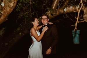 A romantic nighttime wedding portrait with a blue mason jar lantern hanging in the background.