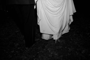 Black and white detail shot of formal wedding attire and shoes.