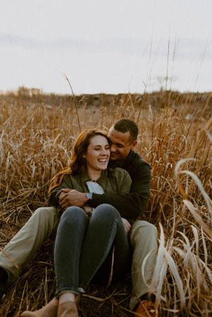 Intimate moment shared among tall grass during autumn sunset.