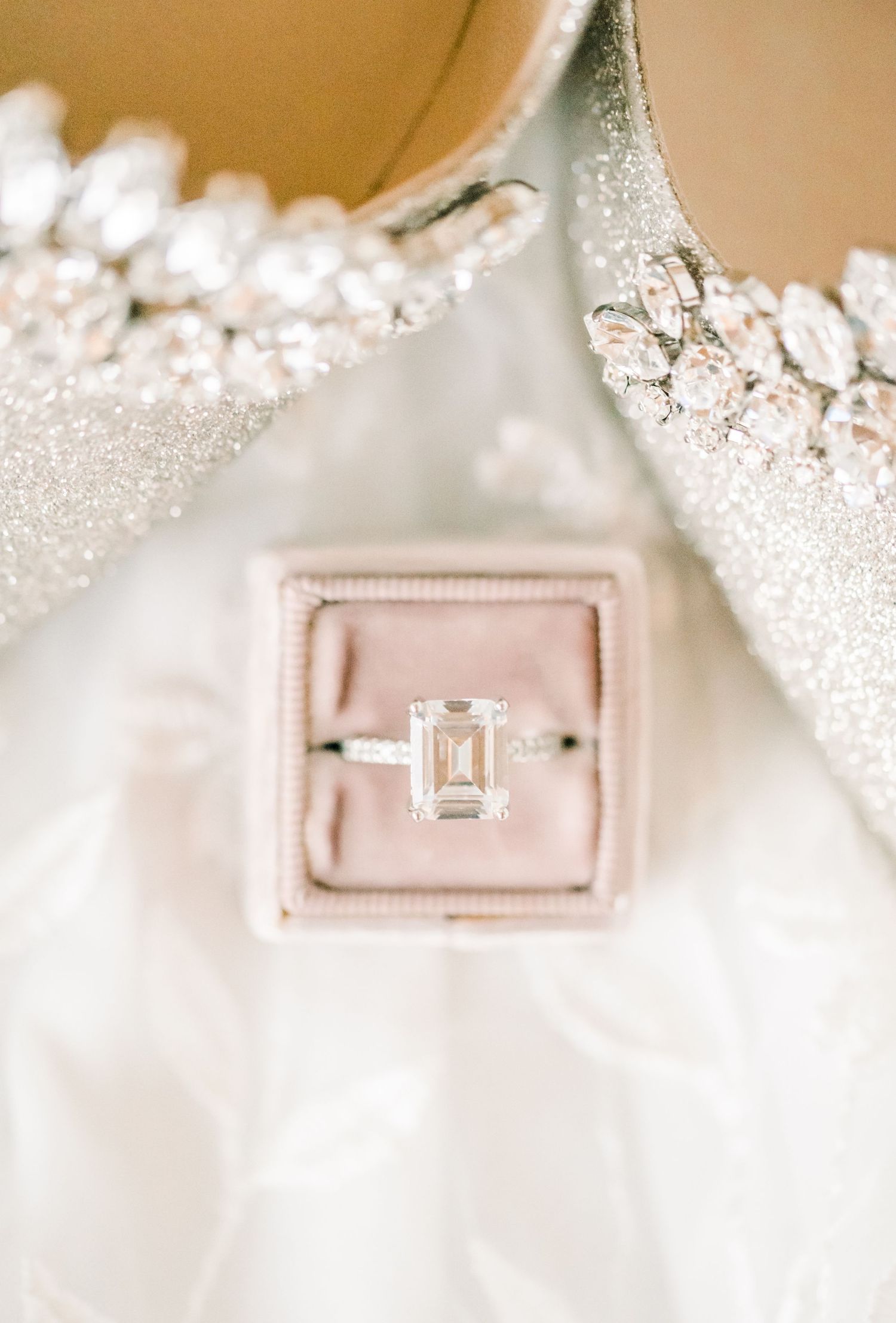 Elegant engagement ring with emerald cut diamond displayed on bridal accessories. Indianapolis, Indiana. Angela Hartwig Photography.