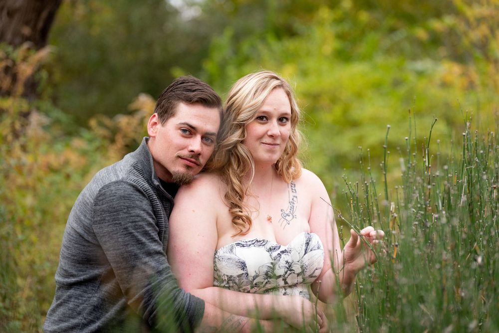 A romantic outdoor photo session with lush green summer foliage in the background.