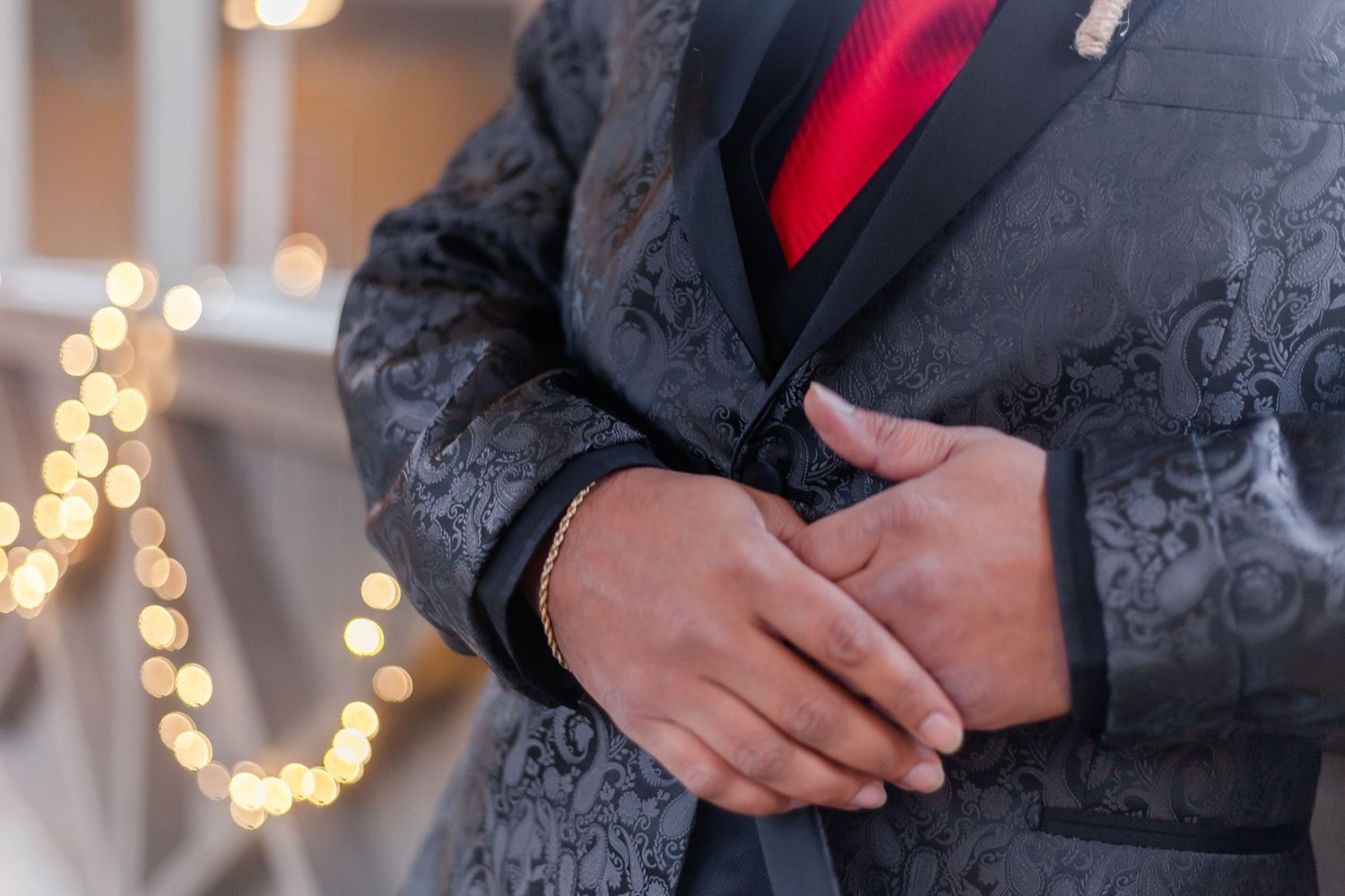Wedding party members in black suits with red accents stand together.