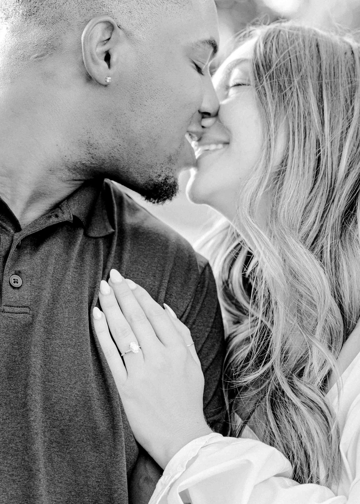 A black and white close-up photo of a romantic moment between a couple.