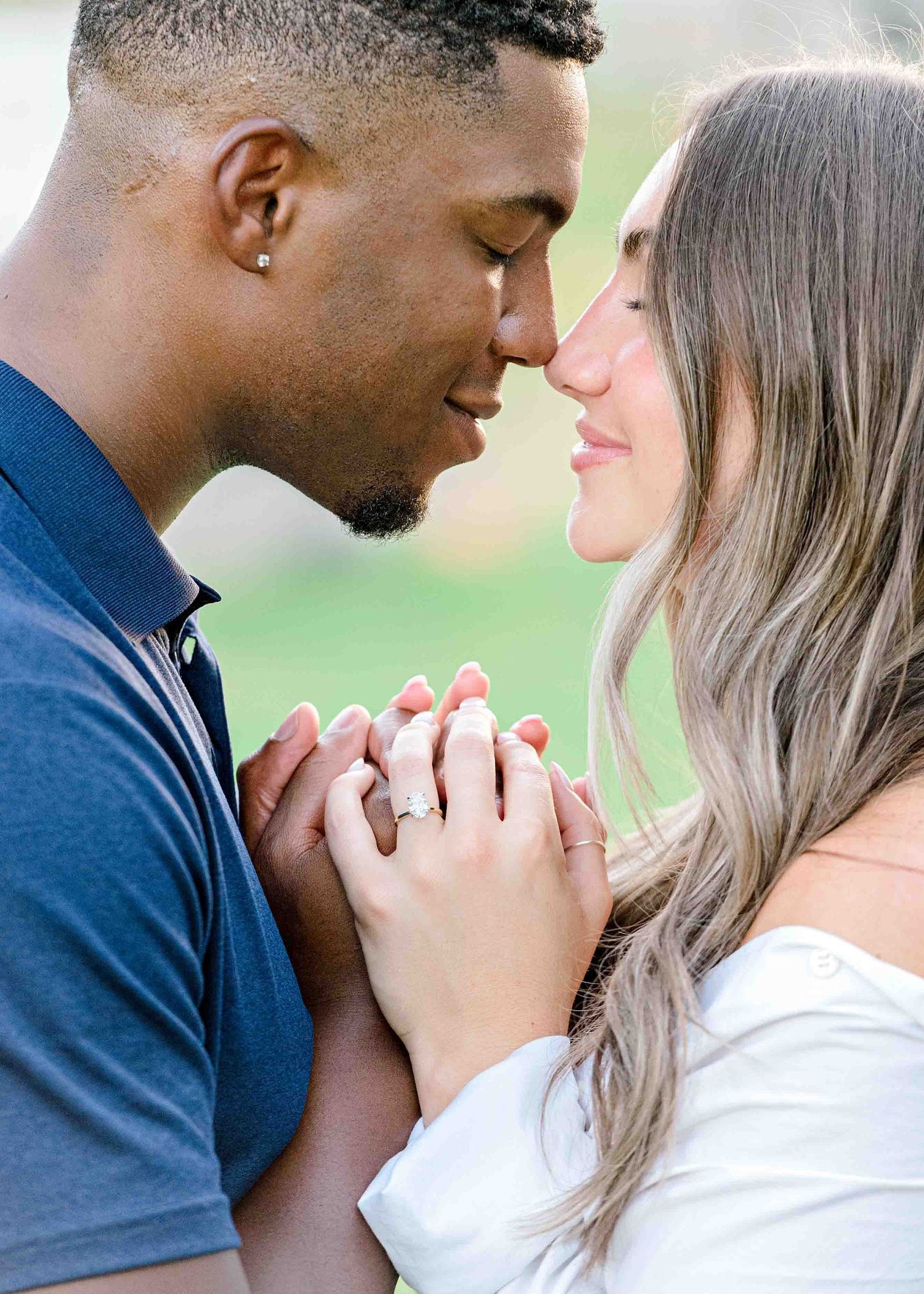 A romantic couple sharing an intimate moment while holding hands outdoors.