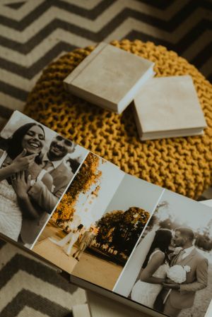 Wedding photo album and boxes resting on a yellow knit surface with chevron pattern in background.
