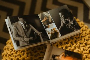 Open wedding photo album displaying black and white photographs on yellow knitted surface.