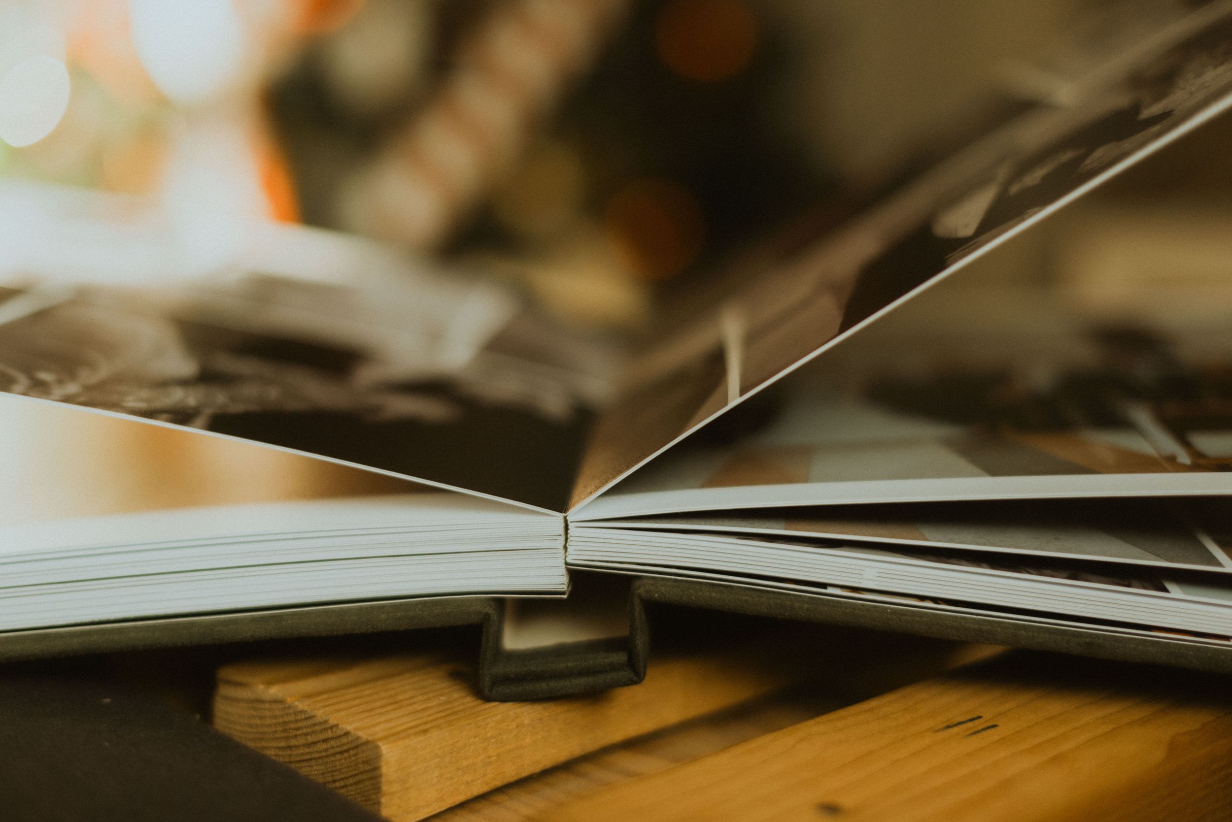 Open book pages spread on wooden surface with shallow depth of field.