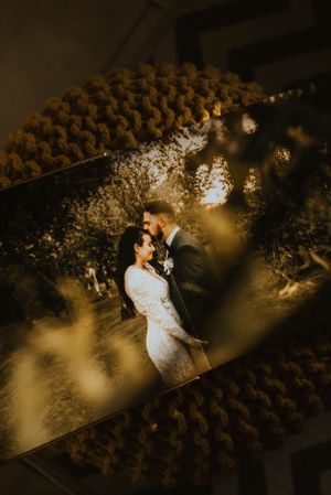 Aerial drone shot of a couple in white attire standing in a vineyard at sunset.