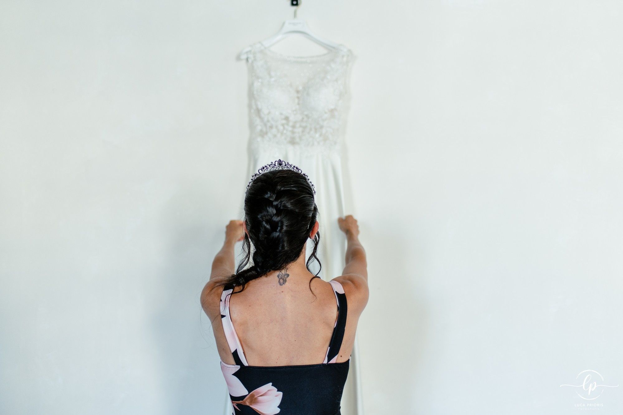 la sposa guarda il suo abito appeso