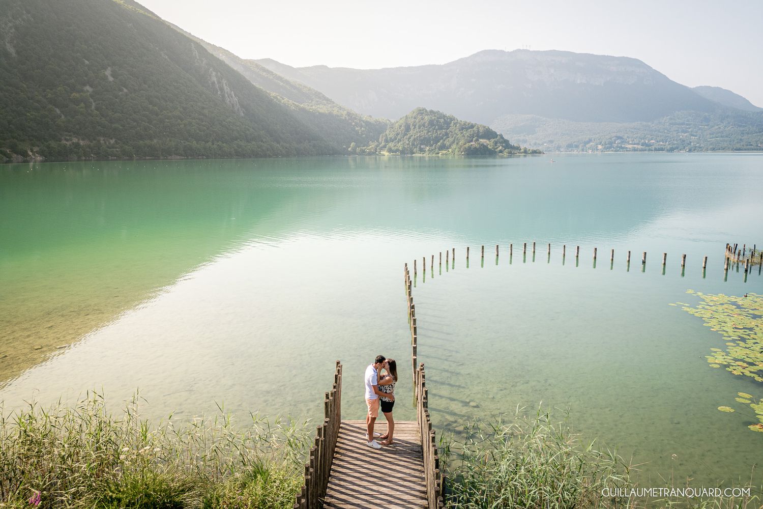 Serene mountain lake views with a wooden pier extending into turquoise waters.