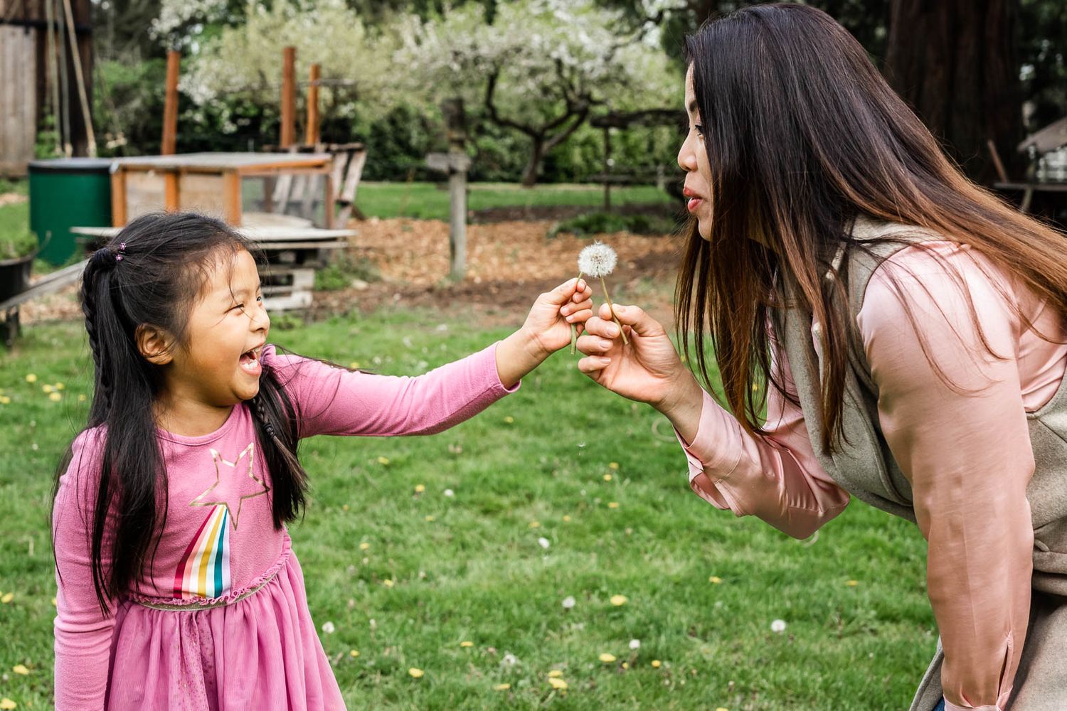 Bellevue photographer capturing mother and daughter blowing dandelion puffs