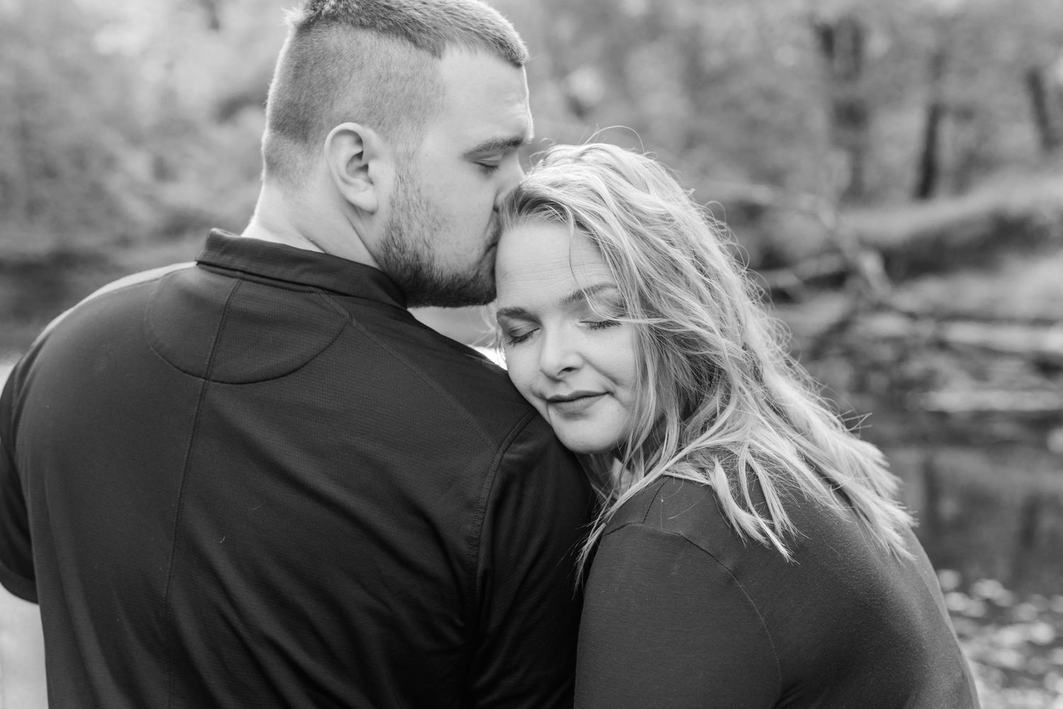 Black and white engagement photos showing intimate moments in a natural setting.