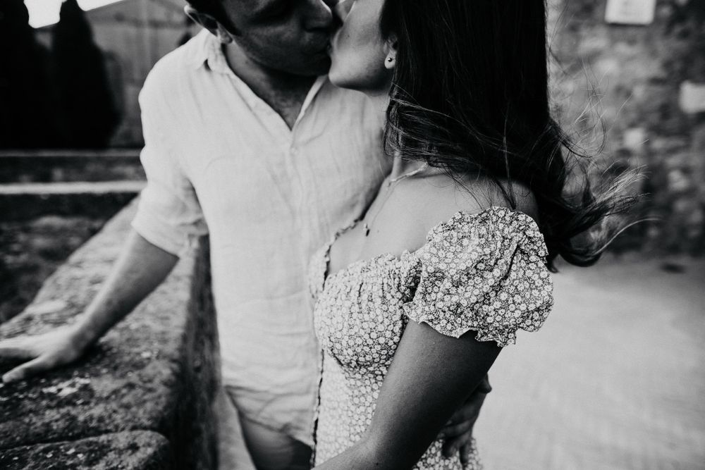 An intimate black and white moment captured against a rustic stone background.