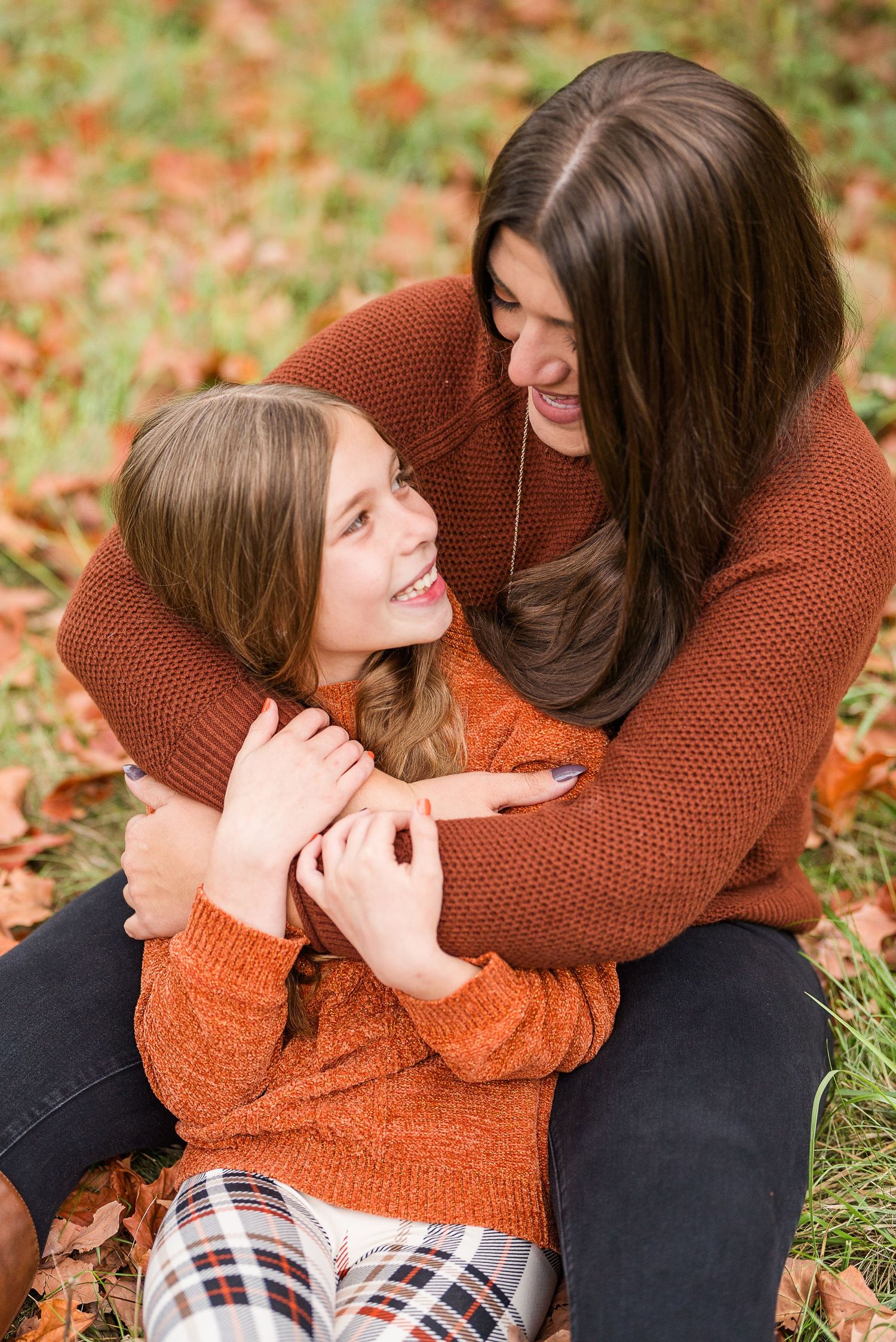 aunt and niece photoshoot at busse woods. sitting in a field posing taken by a milwaukee wedding photographer