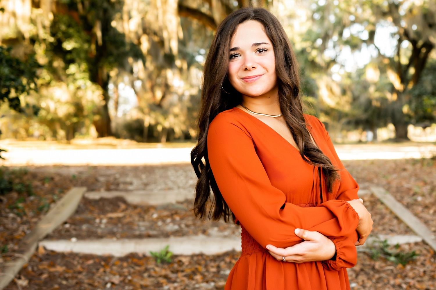 Outdoor portrait series featuring orange and white outfits against a natural wooded backdrop.