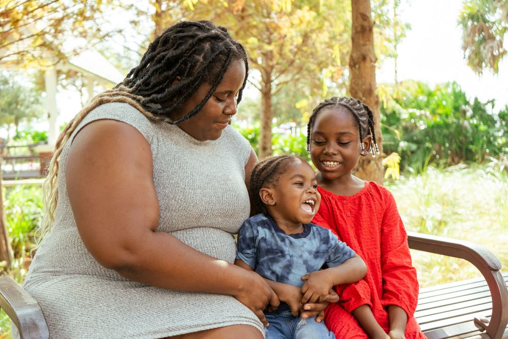 A heartwarming family scene on a park bench surrounded by trees.