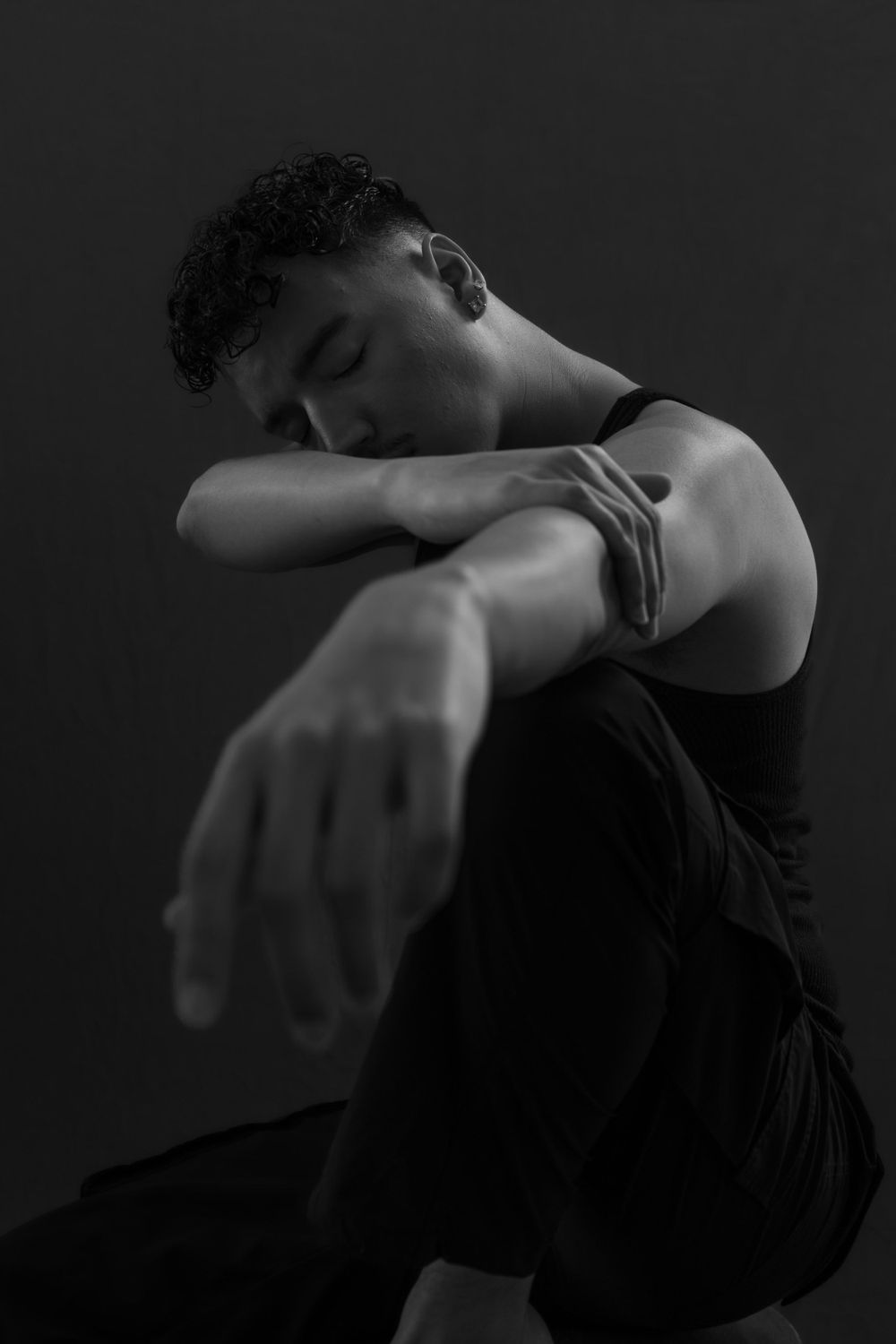 Artistic black and white portrait of a dancer in contemplative pose.