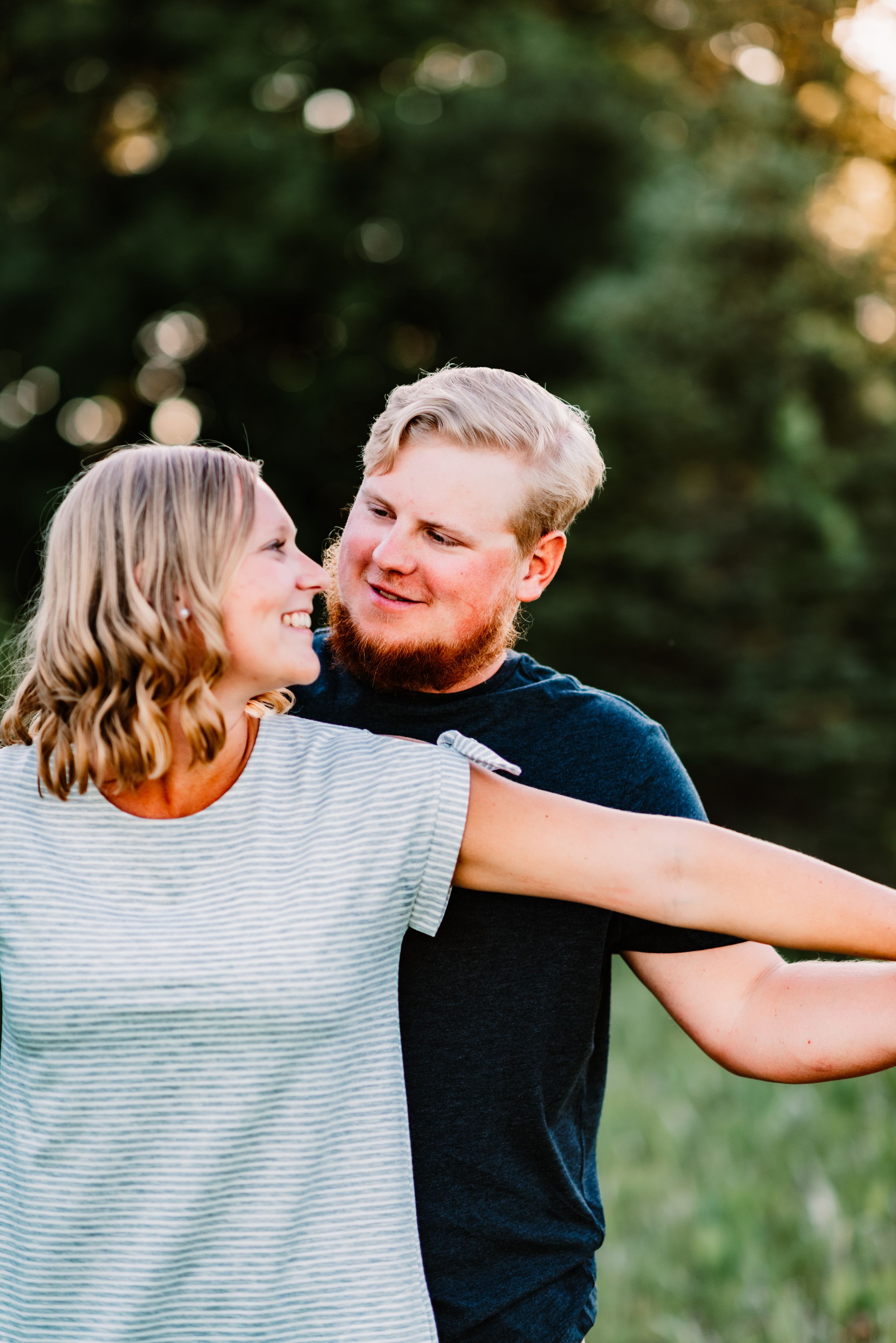 Playful couple laughs together during outdoor photo session.