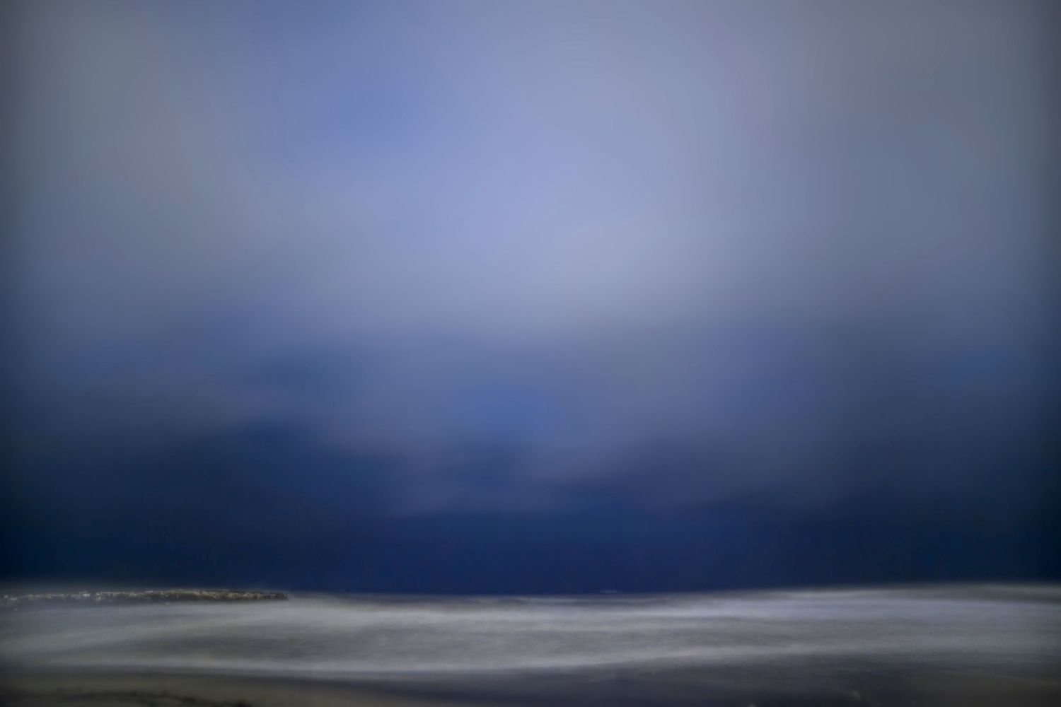 a blurried photography of th sea at night