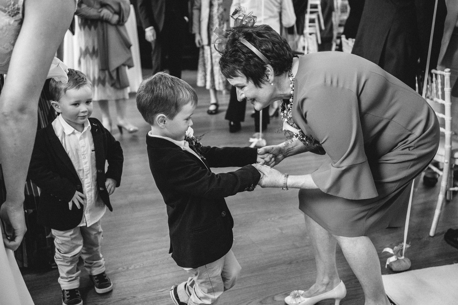 Black and white photo of adults interacting with young children at a formal event.