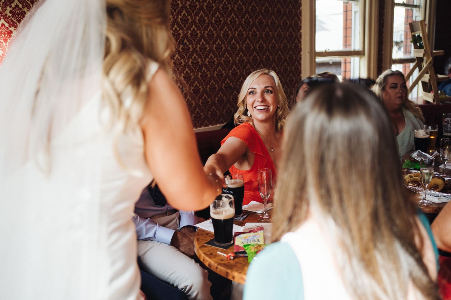 Wedding celebration scene at a restaurant with guests laughing and socializing.