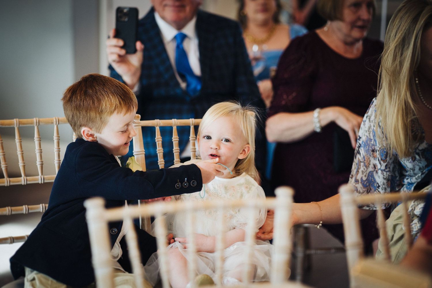 Children interact at an elegant indoor reception with chiavari chairs.