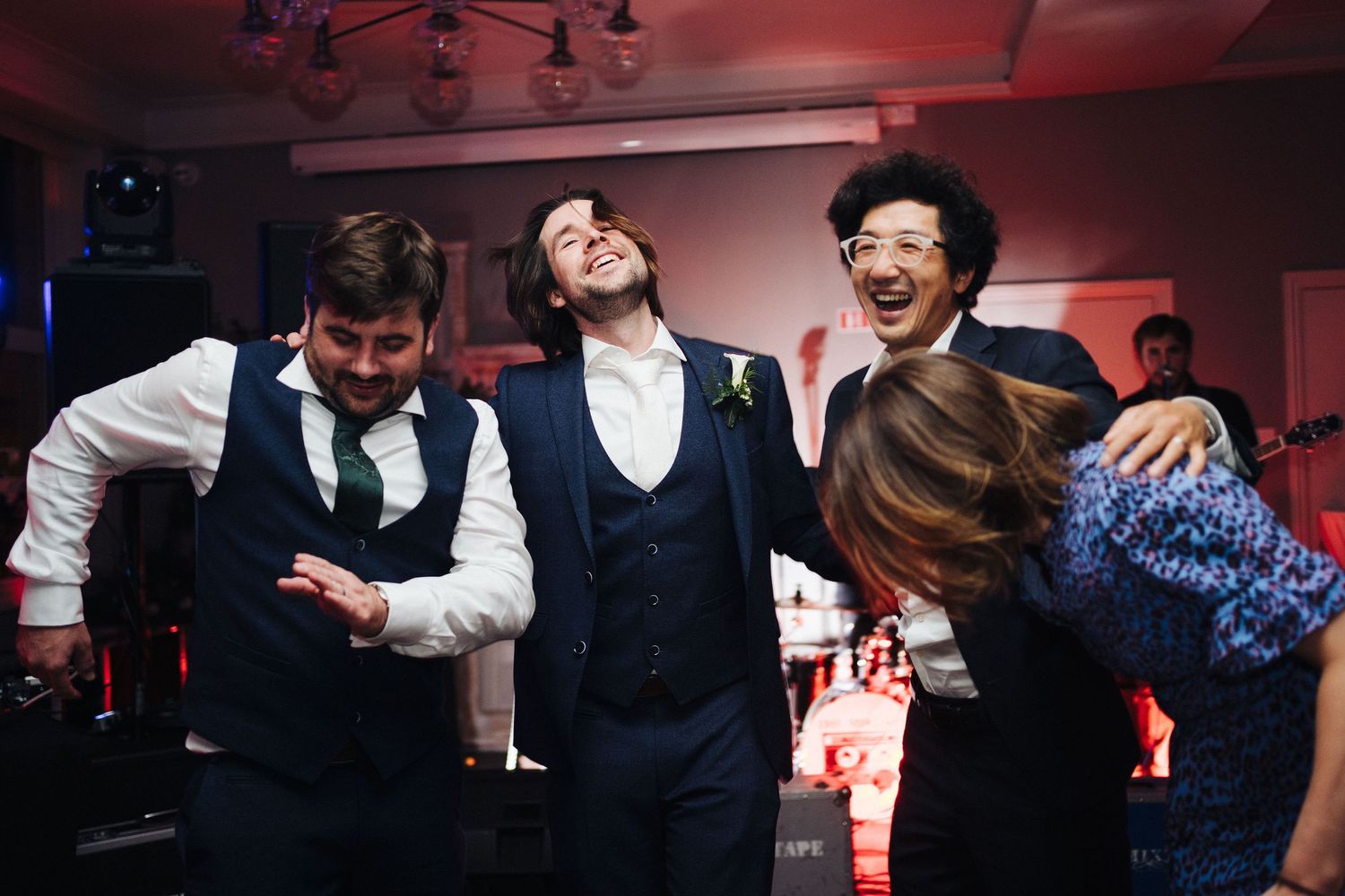 Group of friends laughing and having fun at a dimly lit party.