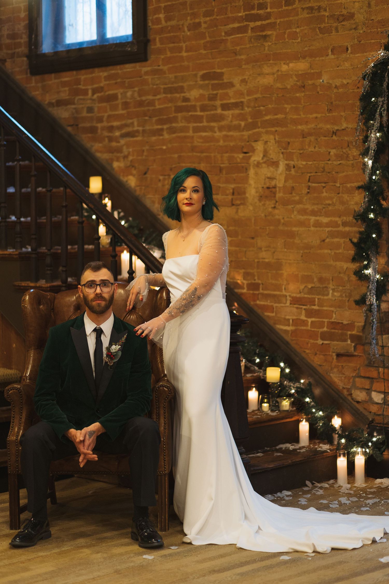 Elegant bride and groom pose in front of a candle lit stair case.