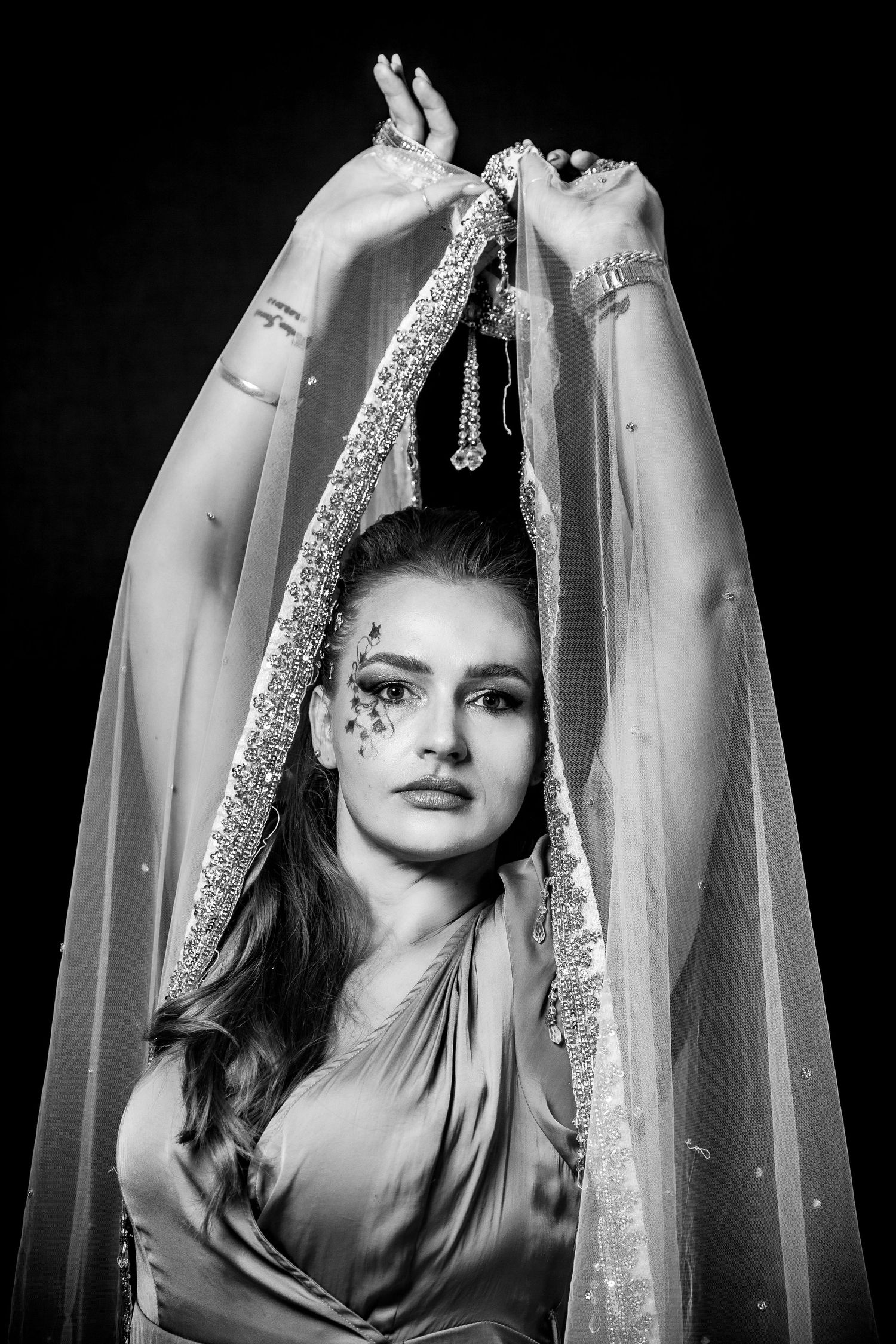 Artistic black and white portrait with flowing fabric and dramatic lighting.