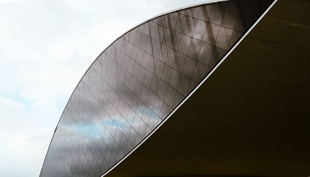 Curved modern architectural structure with metallic surface detail.