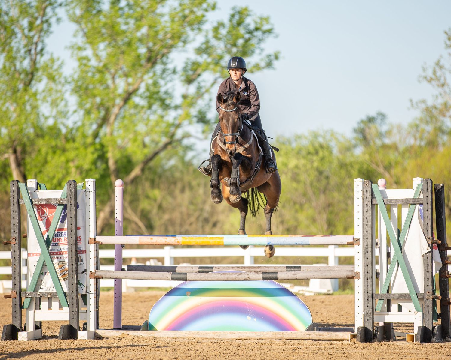 Eventer Julie Wolfert jumping Jaego over a rainbow jump