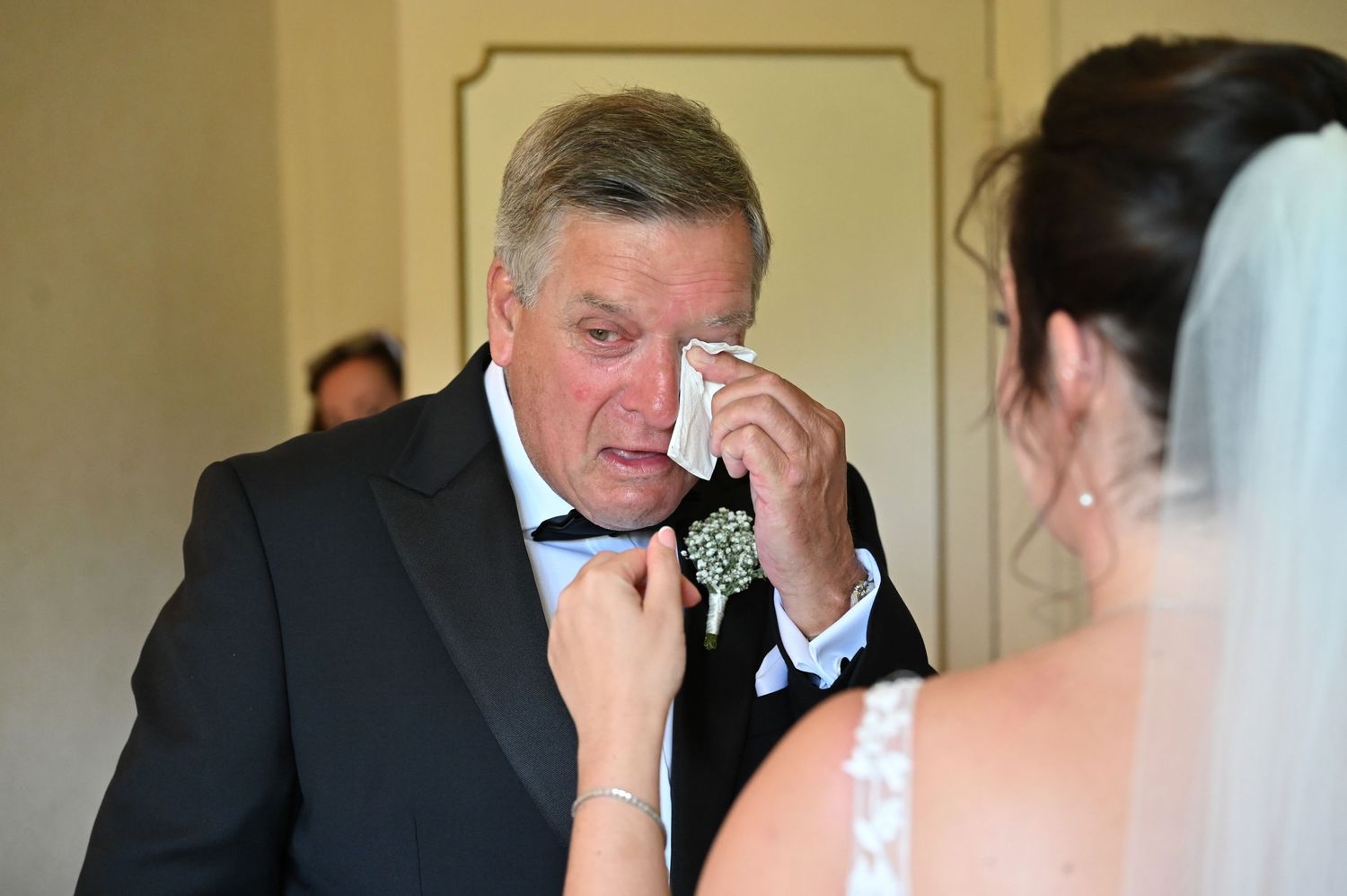 Emotional moment between father and daughter before wedding ceremony.