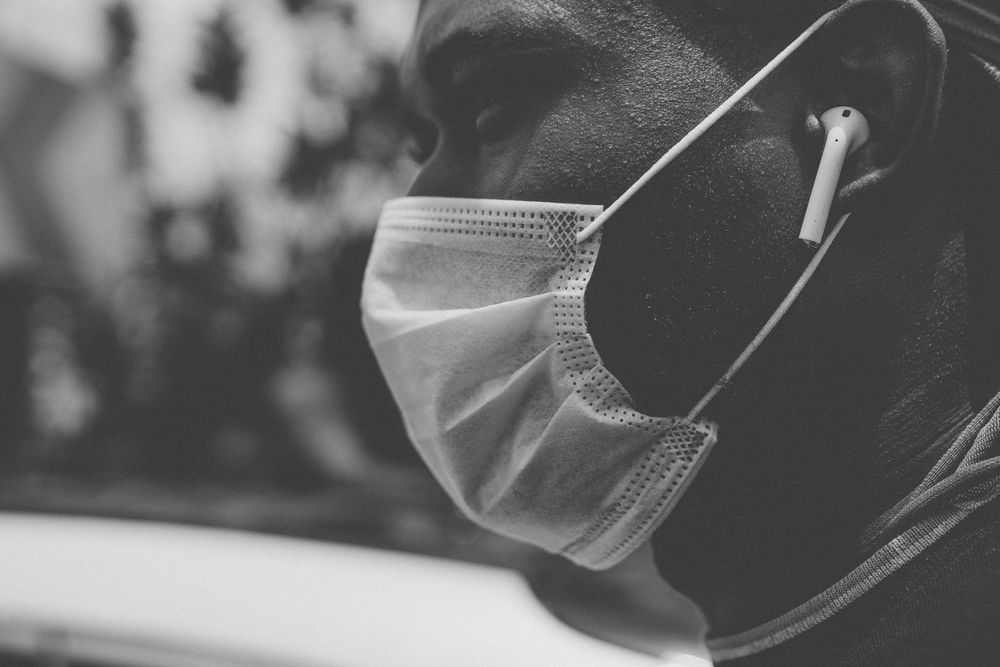 Medical professionals wearing protective masks attend to patients in a healthcare setting.