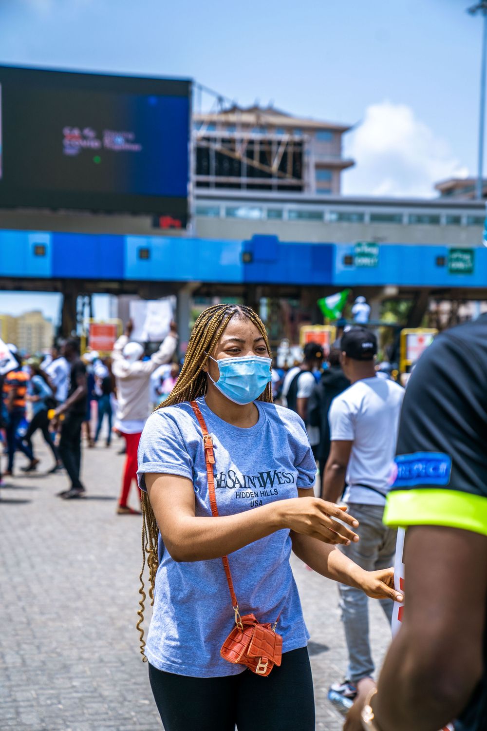 Crowd of people gathered outside a shopping center wearing face masks during pandemic.