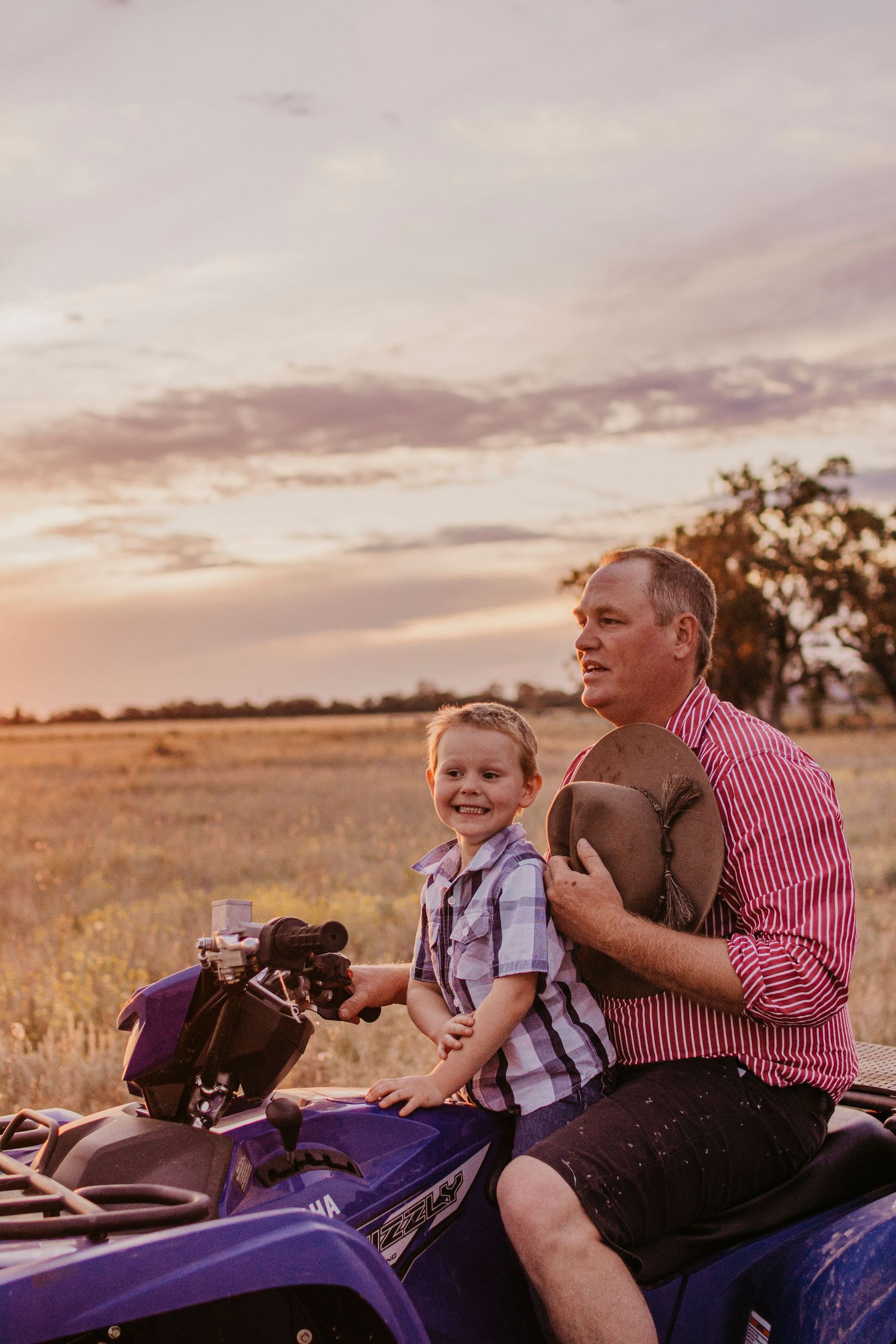 Rural farming family, riding motorbike in a paddock at sunset, Warren NSW