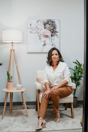 Business casual portrait in modern office with floral art and tripod lamp.