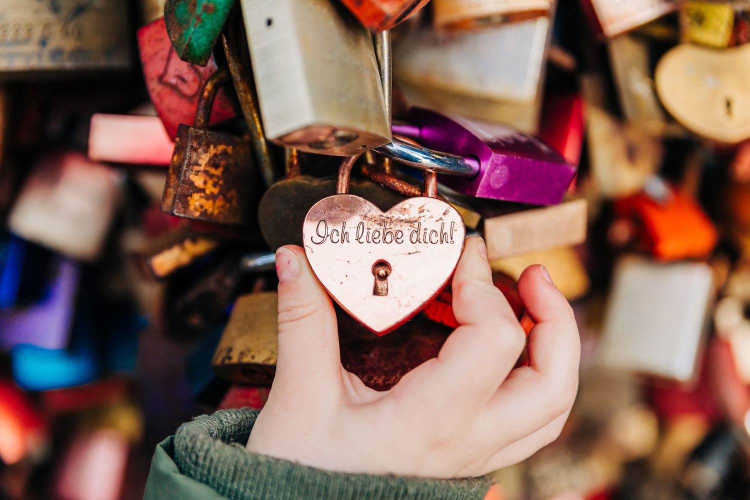 Close-up of a heart-shaped padlock among many colorful locks.