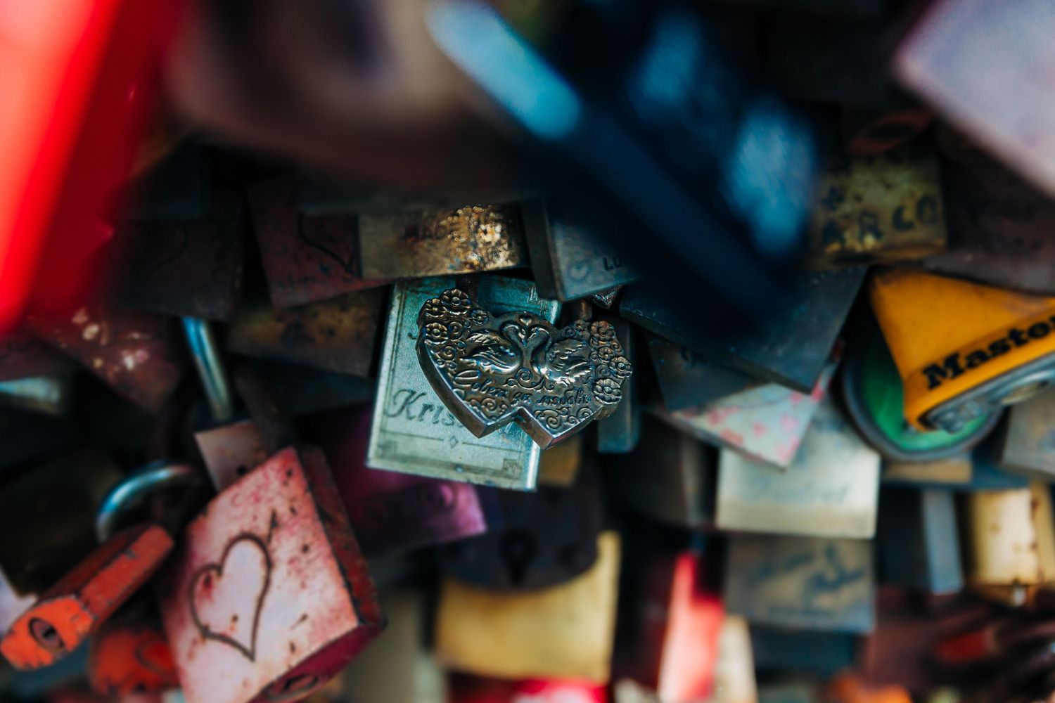 Close-up detail of colorful love locks attached to bridge railing in Cologne.