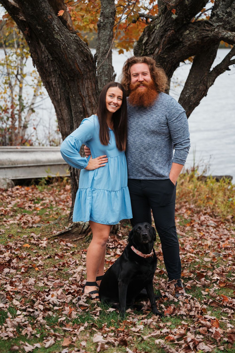 Couple posing with dog on Pelican Lake in Orr, Minnesota.