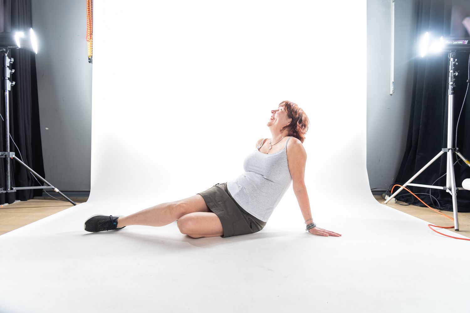 Photography studio setup with white backdrop and professional lighting equipment.