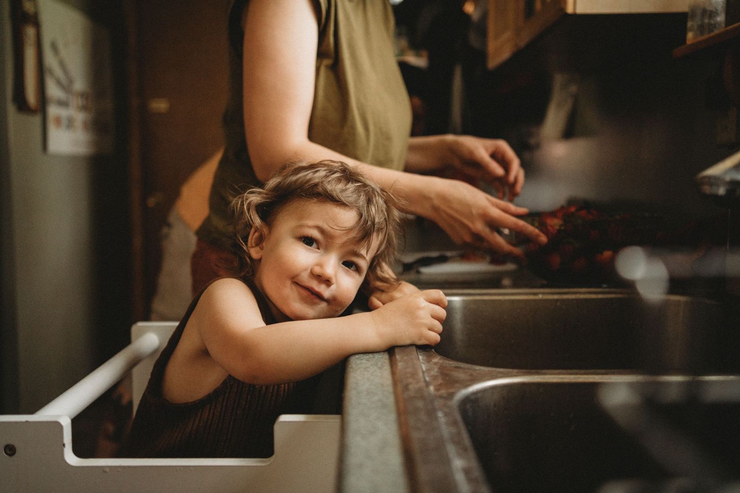 A joyful moment captured while doing dishes at the kitchen sink.