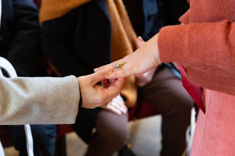 Close-up shot of hands exchanging something during a ceremony.