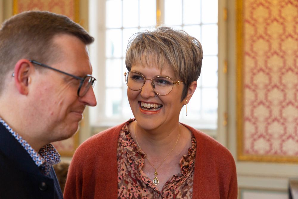A candid moment of genuine laughter shared between two people in a formal setting.