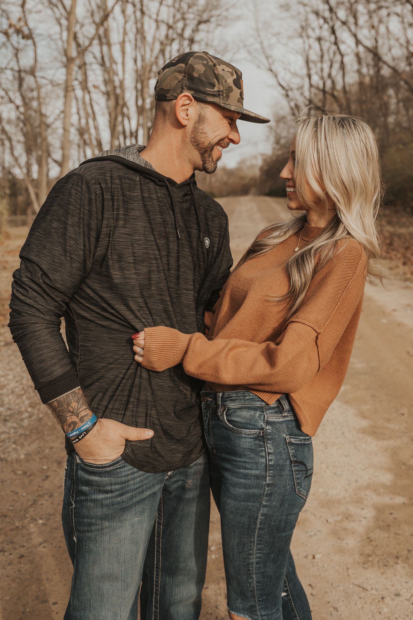 Casual couple embracing on a dirt path during an autumn day near Spring Arbor MI>