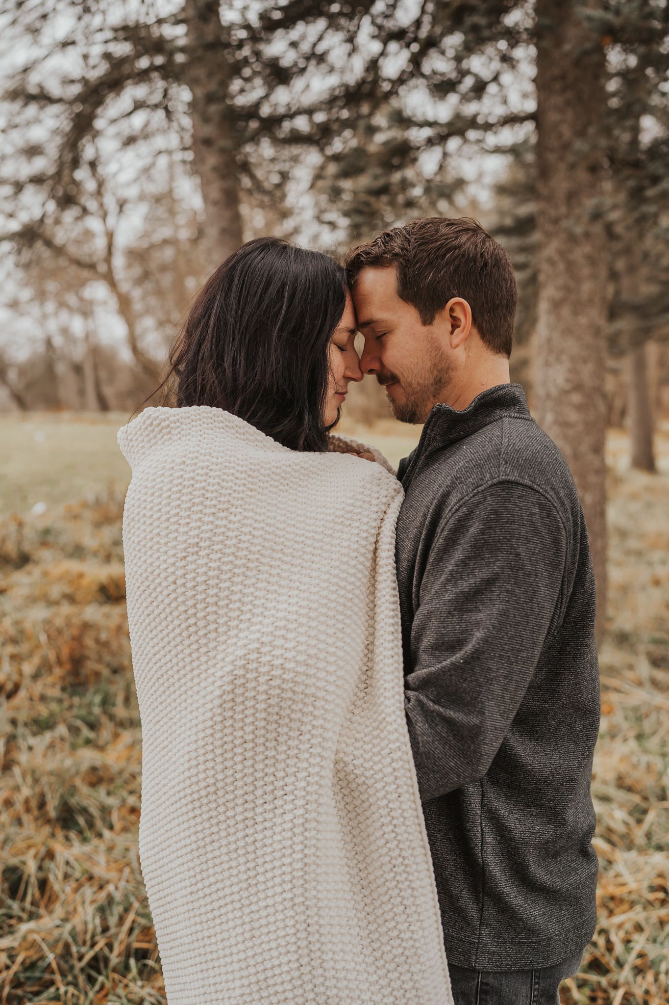 Intimate moment shared between couple wearing cozy sweaters in autumn setting.