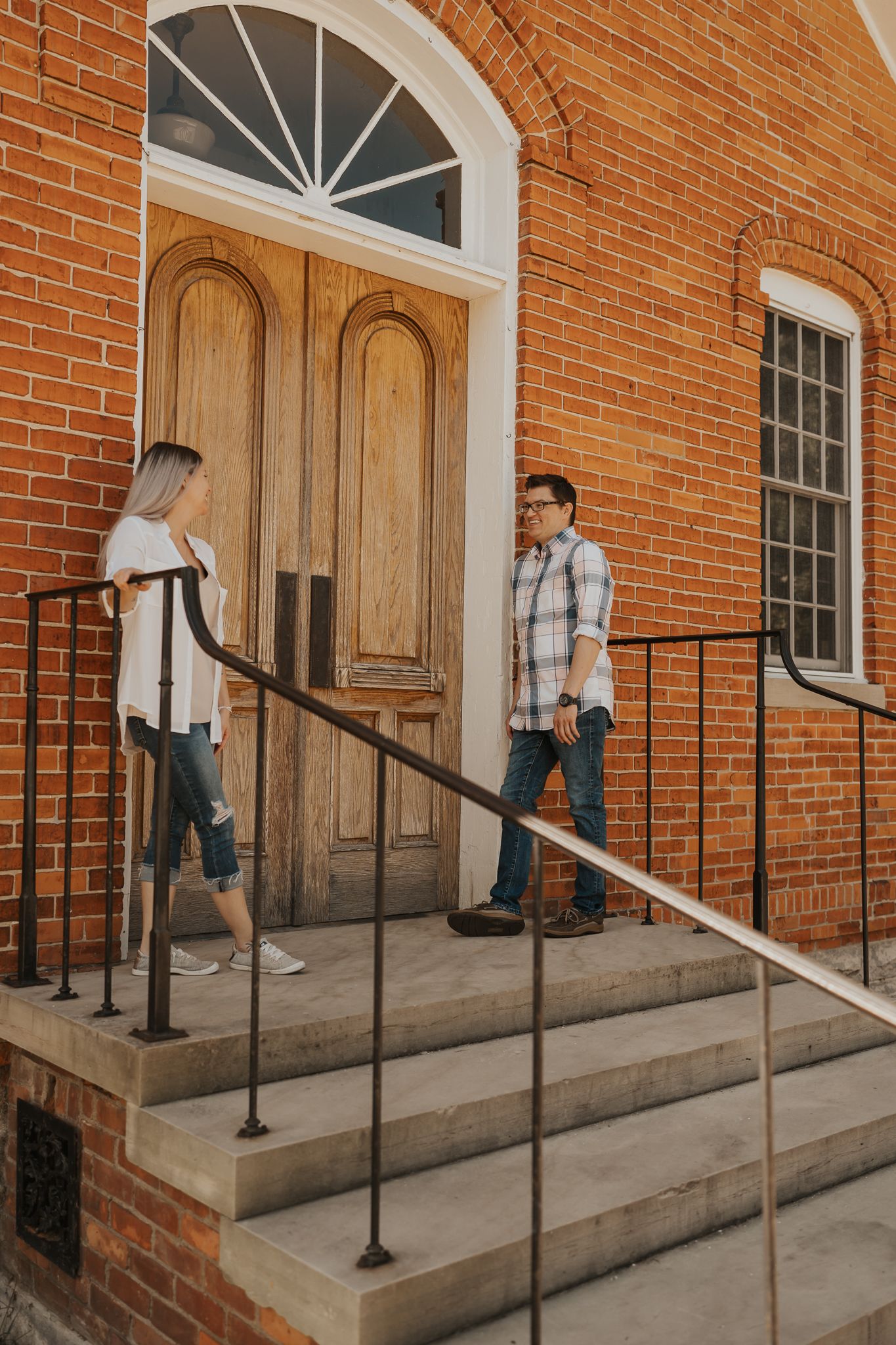 Historic brick building entrance with arched doorways and concrete steps.